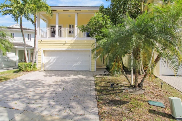 view of front facade featuring a garage and a balcony