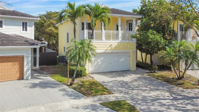 view of front of home featuring cooling unit, a balcony, and a garage