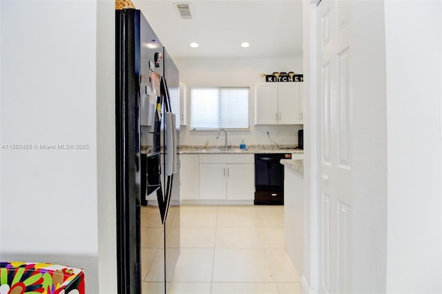 kitchen featuring white cabinetry, light tile patterned floors, sink, and black appliances