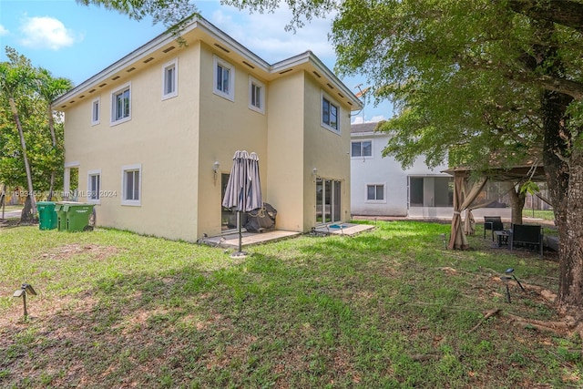 rear view of property featuring a lawn