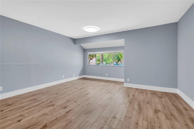 empty room with lofted ceiling and light wood-type flooring