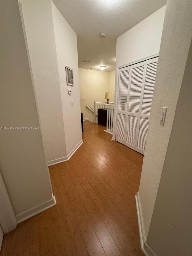 corridor with hardwood / wood-style flooring