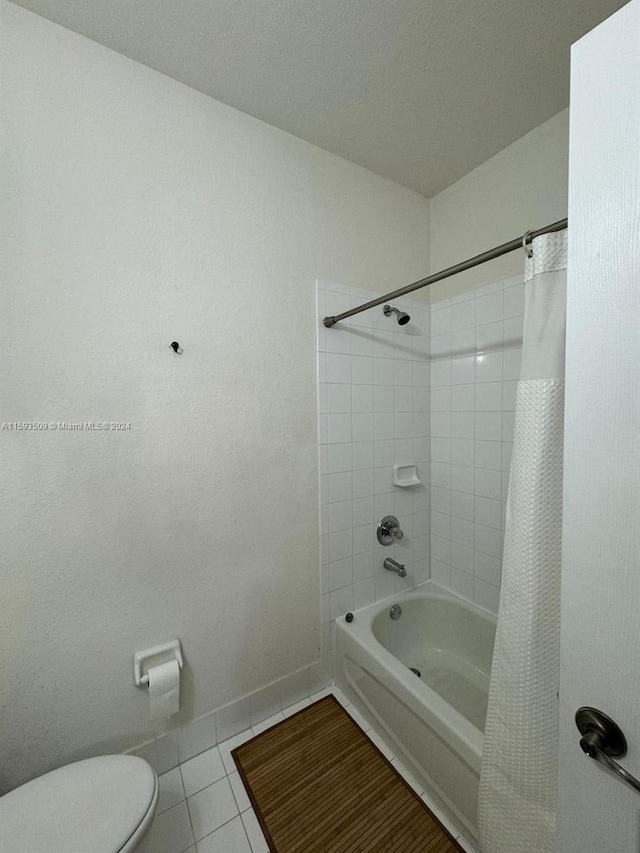 bathroom featuring tile flooring, shower / bath combo, and toilet