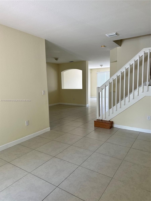 unfurnished room featuring tile flooring and a textured ceiling