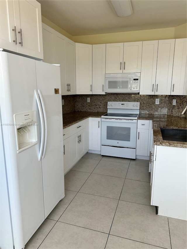 kitchen featuring tasteful backsplash, white appliances, and white cabinetry