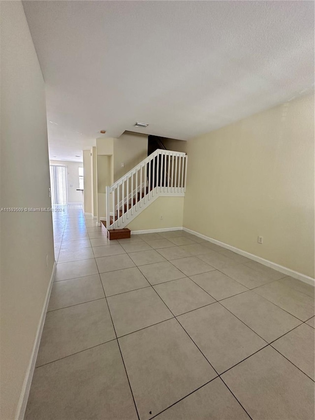 empty room with tile floors and a textured ceiling