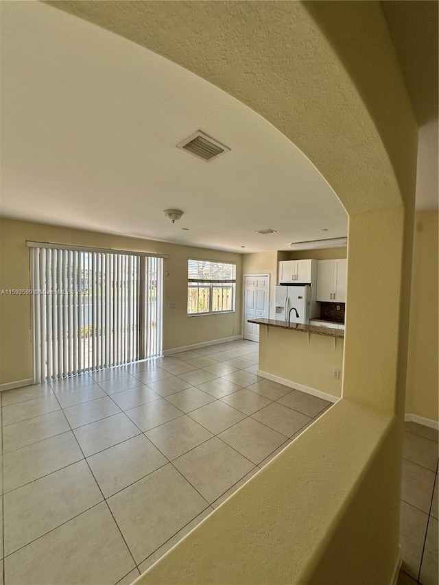 spare room featuring sink and light tile flooring