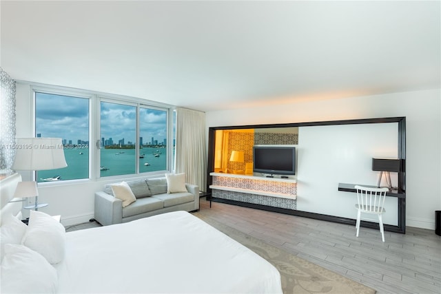 bedroom featuring hardwood / wood-style floors and a water view