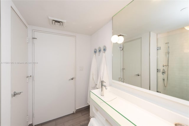 bathroom featuring an enclosed shower and wood-type flooring