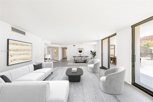 living room featuring floor to ceiling windows and a textured ceiling