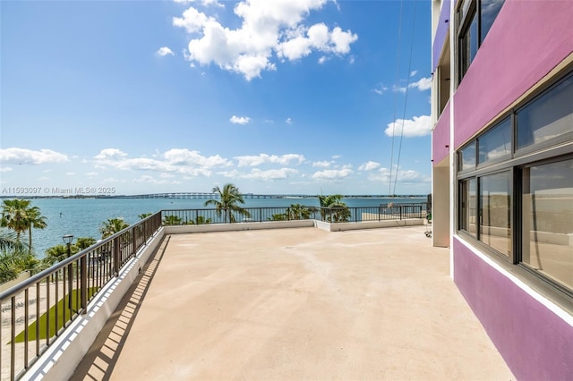 view of patio with a water view and a balcony