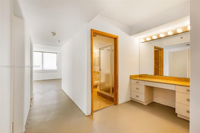 bathroom with concrete floors, a shower, and vanity