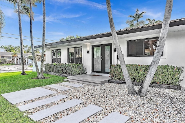 ranch-style home featuring a front lawn and french doors