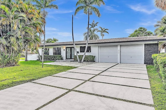 ranch-style house with a garage and a front lawn