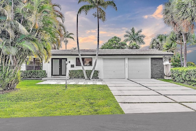 ranch-style house with a yard and a garage