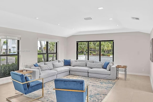 tiled living room with vaulted ceiling and a healthy amount of sunlight