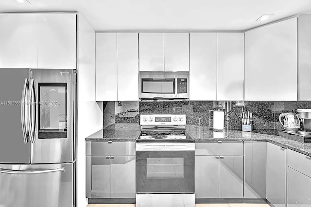 kitchen with white cabinetry, dark stone counters, and appliances with stainless steel finishes