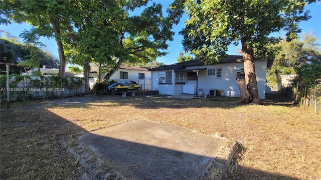 back of house featuring central AC and a lawn