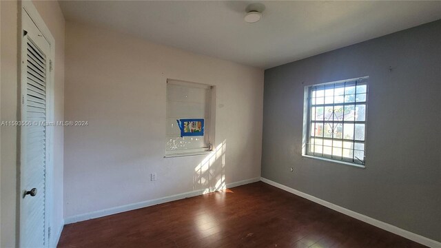 empty room with dark hardwood / wood-style flooring