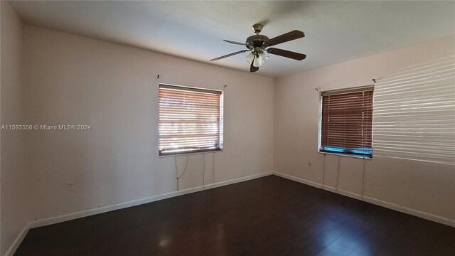 unfurnished room with ceiling fan and dark hardwood / wood-style flooring