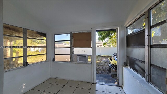 unfurnished sunroom featuring cooling unit and lofted ceiling