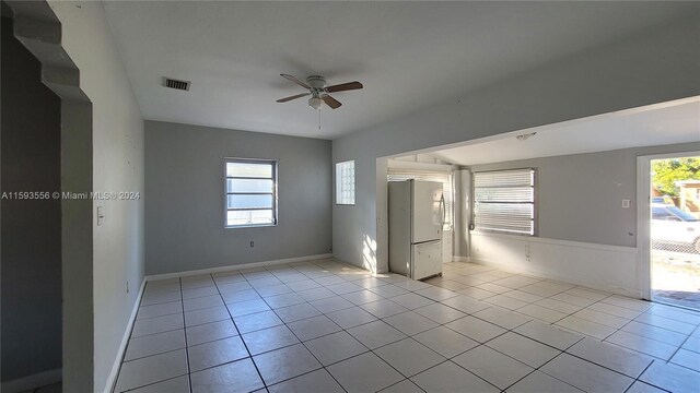 tiled spare room with ceiling fan