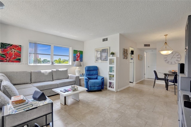 living room featuring light tile floors and a textured ceiling