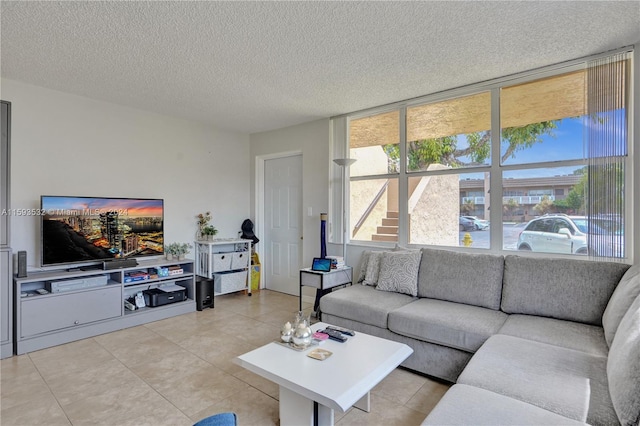 living room featuring a healthy amount of sunlight, a textured ceiling, and light tile floors