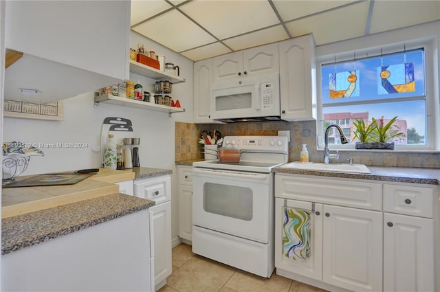 kitchen featuring white cabinetry, white appliances, backsplash, sink, and light tile floors