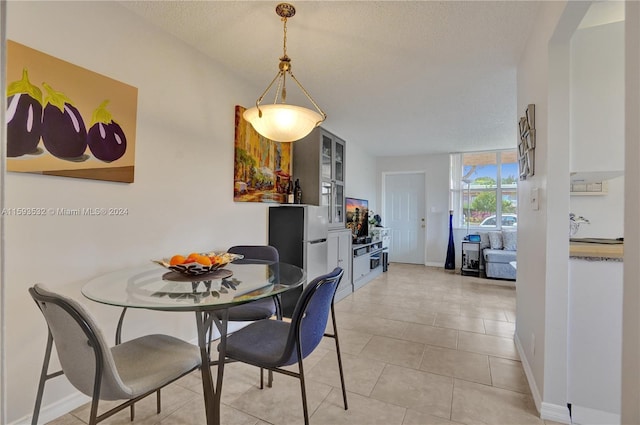 tiled dining area with a textured ceiling