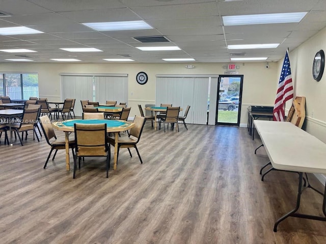 dining space with hardwood / wood-style floors and a paneled ceiling