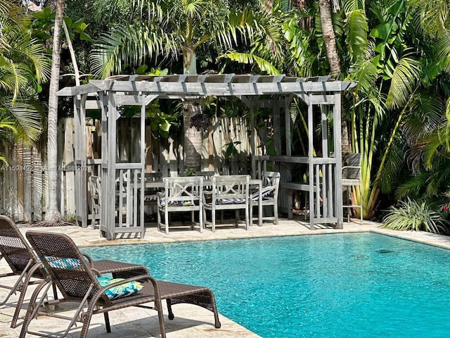 view of swimming pool with a patio and a pergola