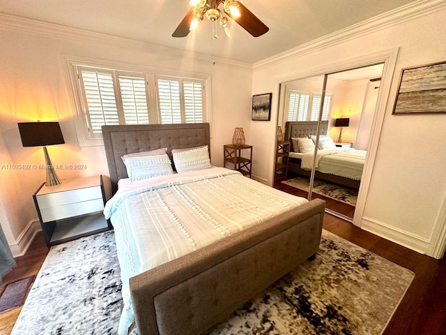 bedroom with a closet, ceiling fan, crown molding, and dark hardwood / wood-style floors