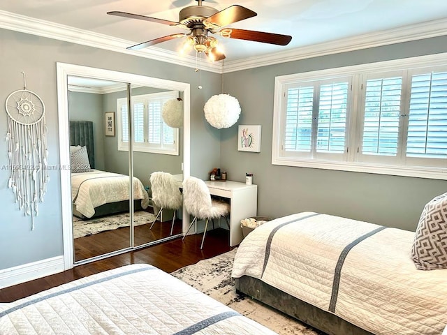 bedroom with dark wood-type flooring, ceiling fan, a closet, and multiple windows