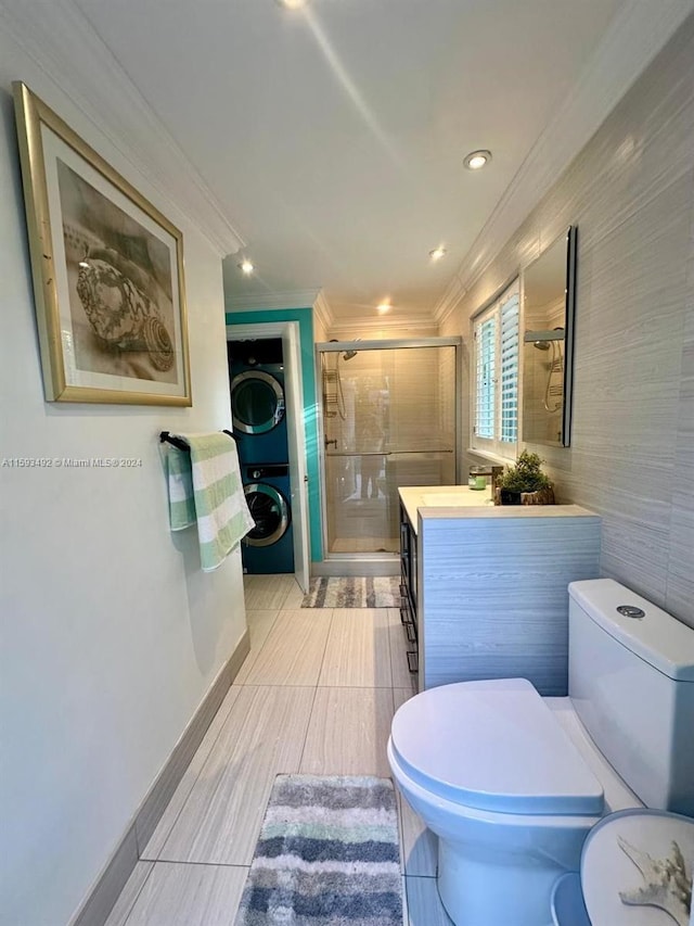 bathroom with stacked washing maching and dryer, toilet, a shower with shower door, vanity, and crown molding