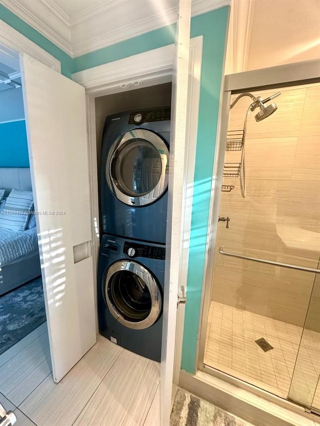 washroom featuring ornamental molding and stacked washer and clothes dryer