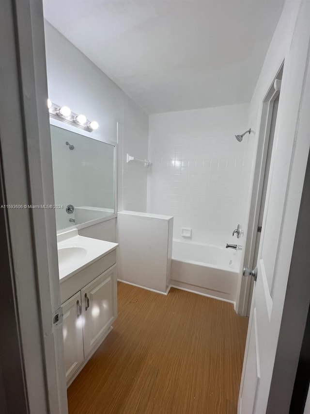 bathroom with hardwood / wood-style floors, vanity, and bathtub / shower combination