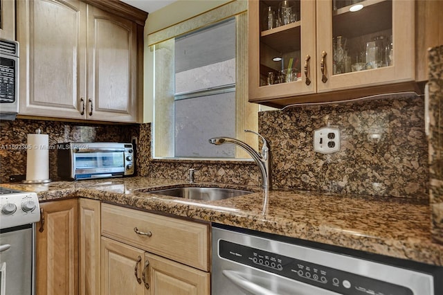 kitchen featuring dishwasher, sink, and backsplash