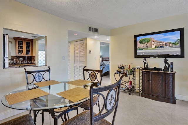 tiled dining area featuring a textured ceiling