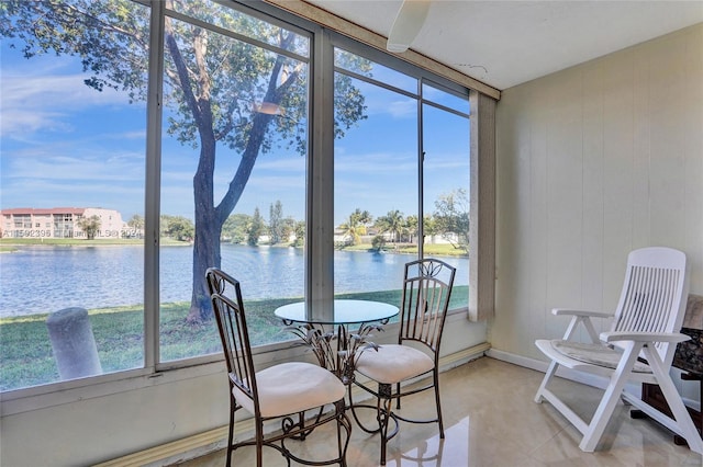 sunroom featuring a water view