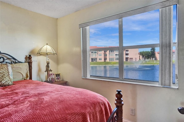 bedroom featuring a textured ceiling and a water view