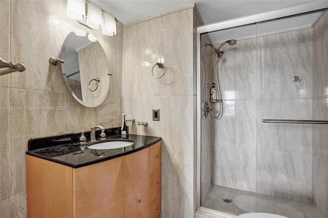 bathroom with an enclosed shower, vanity, toilet, and tile walls