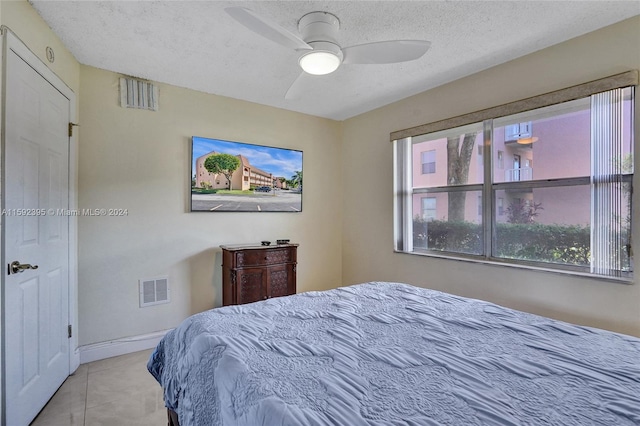 tiled bedroom featuring a textured ceiling and ceiling fan