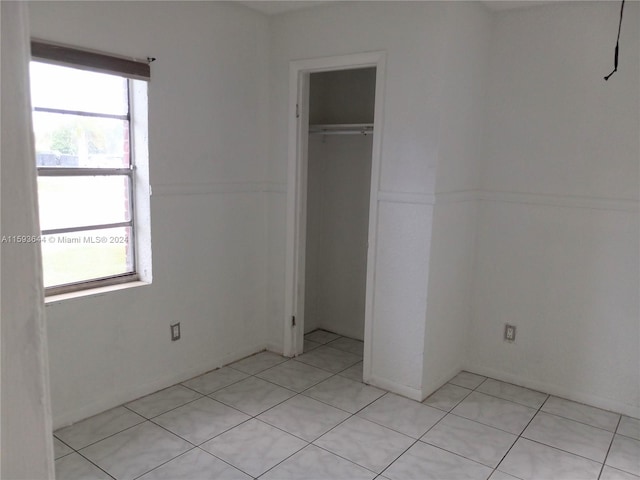unfurnished bedroom featuring a closet and light tile patterned flooring