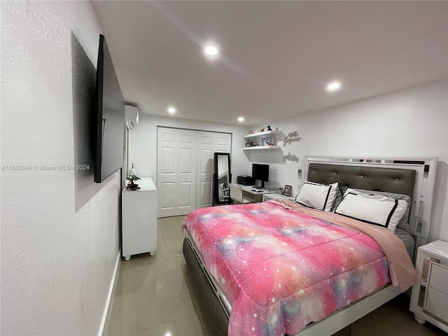 bedroom with a wall mounted air conditioner, tile patterned floors, and a closet