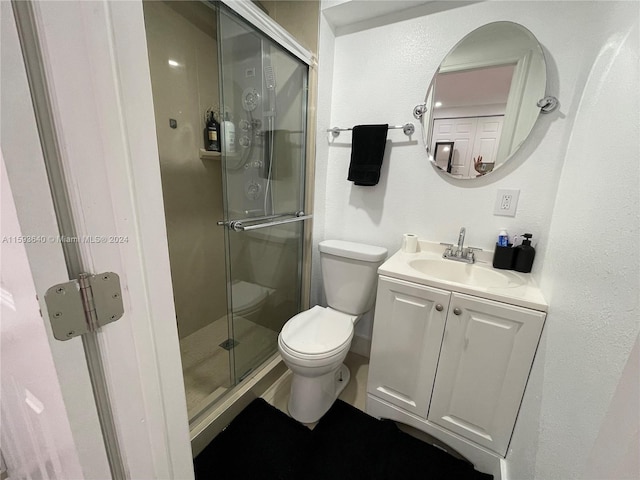 bathroom featuring vanity, walk in shower, and toilet