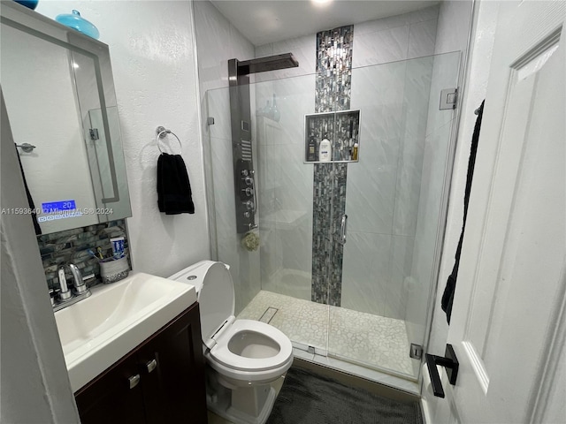 bathroom with vanity, toilet, and a shower with door