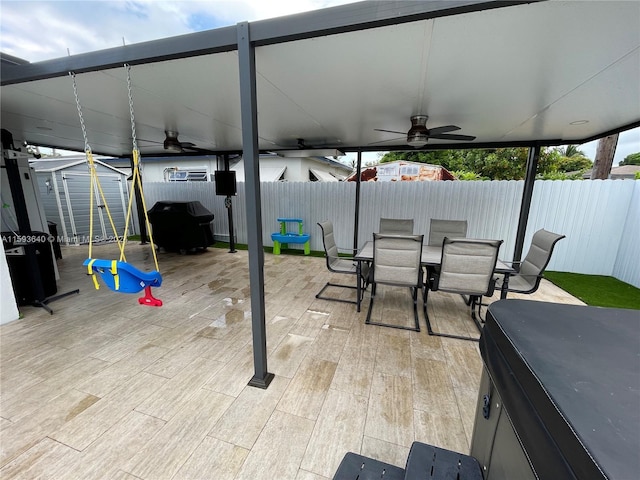 view of patio / terrace with ceiling fan, a storage unit, and a grill