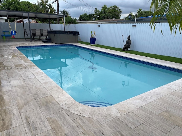 view of swimming pool with a hot tub and a patio