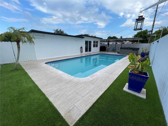 view of pool with a hot tub, a patio, and a yard